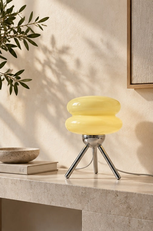 Cream-yellow Ripple Glass Tripod Table Lamp on a light stone console, with its power cord visible